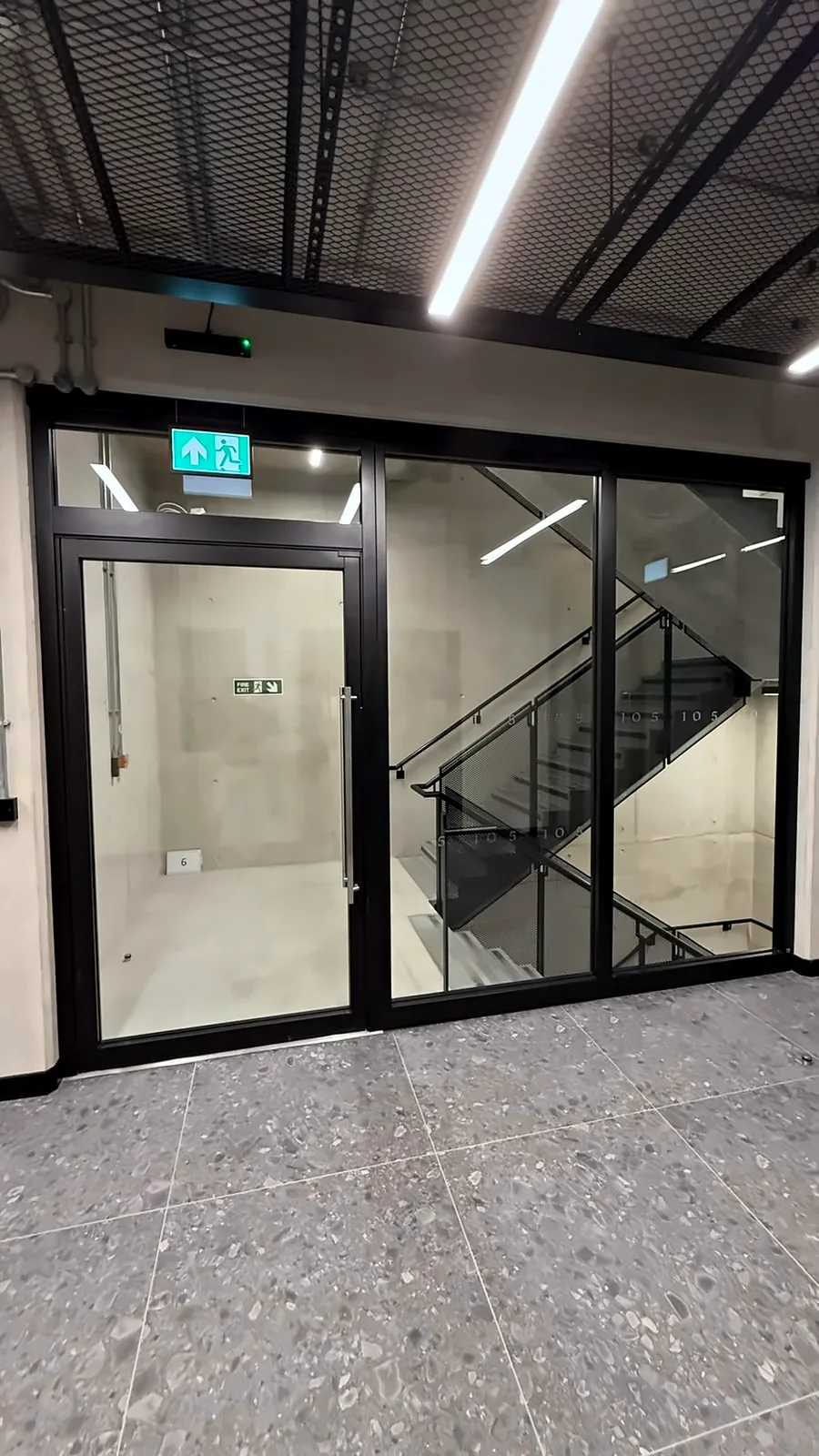 A fire door and glazed fire screen enclosing the stair core.