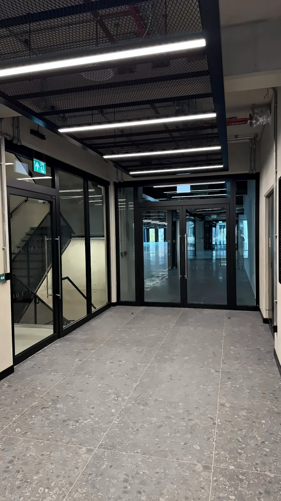 Glazed fire screens and double doors along a lift core corridor.
