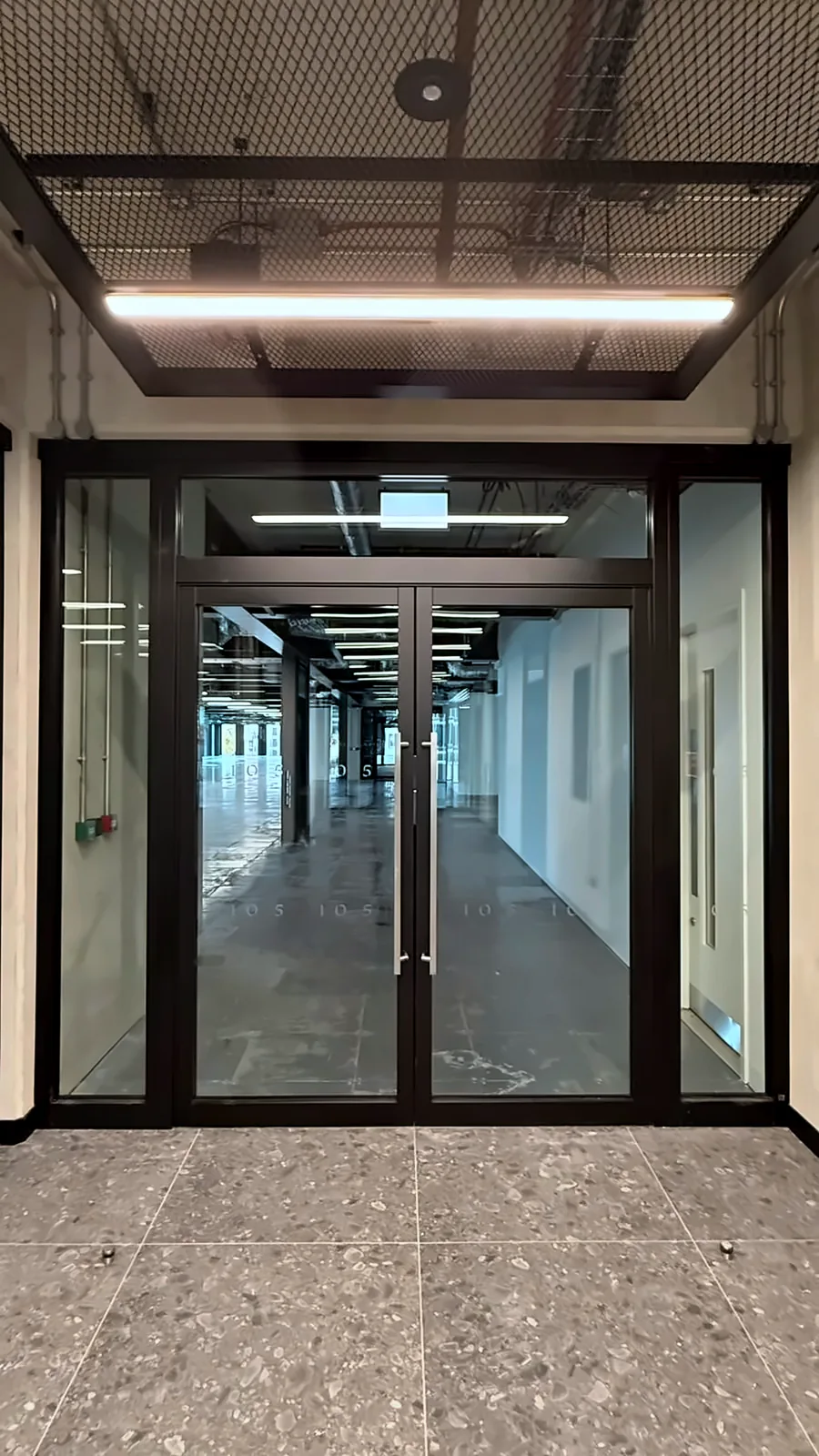 Double fire doors between the lift core and an office floor.