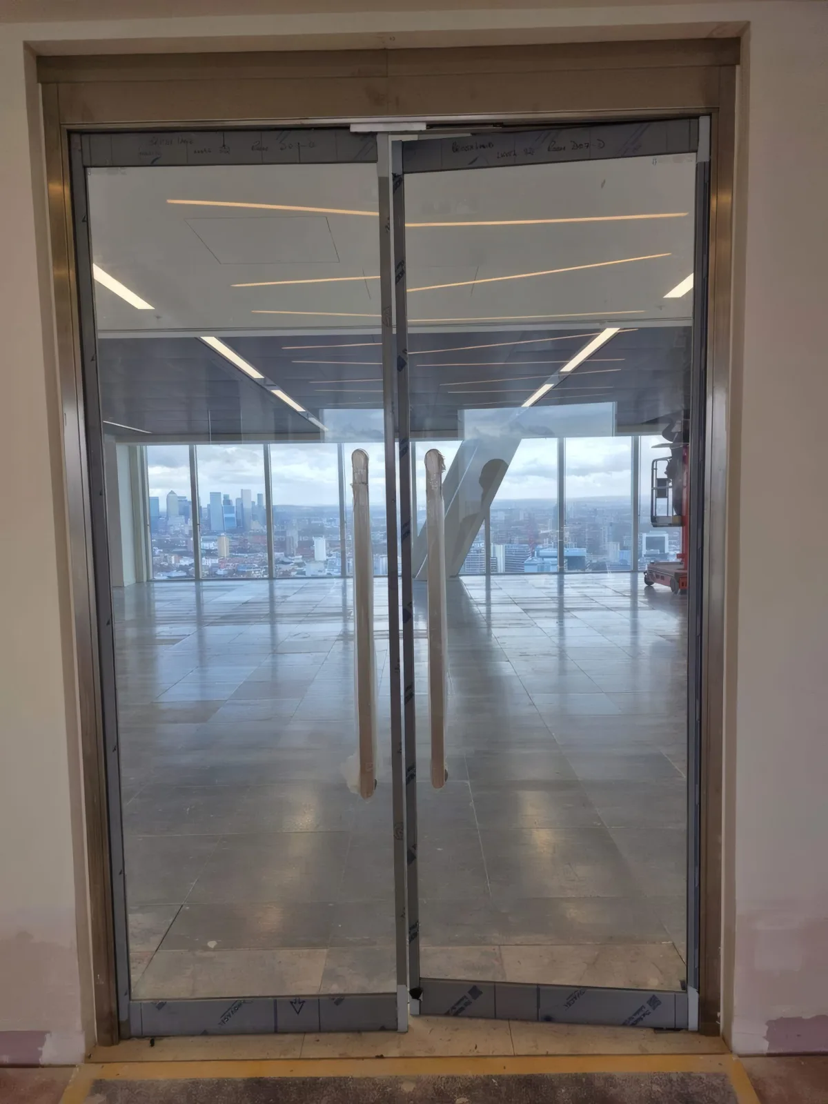 Fire-rated glazed double doors installed by OMFC for Structure Tone, with London views beyond.