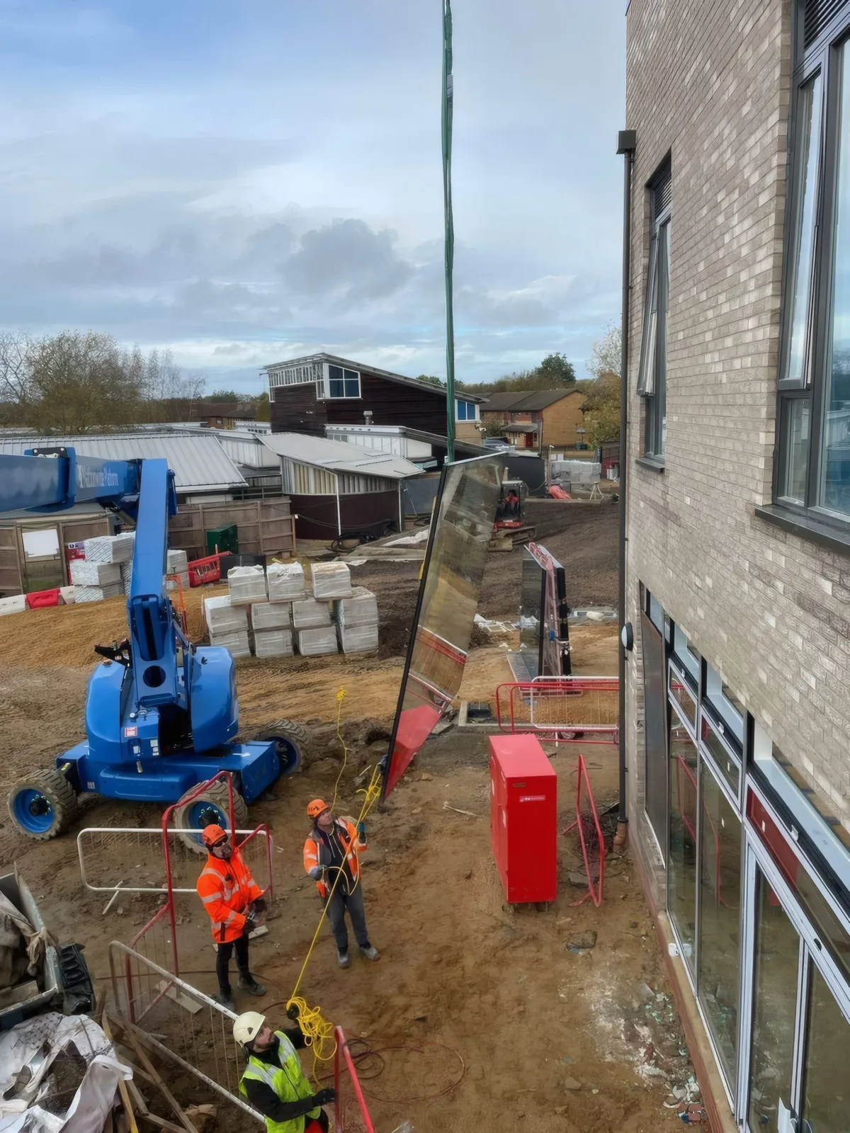 A glazing unit being lifted into position at the student residential development, using a mobile crane and vacuum lifting equipment.