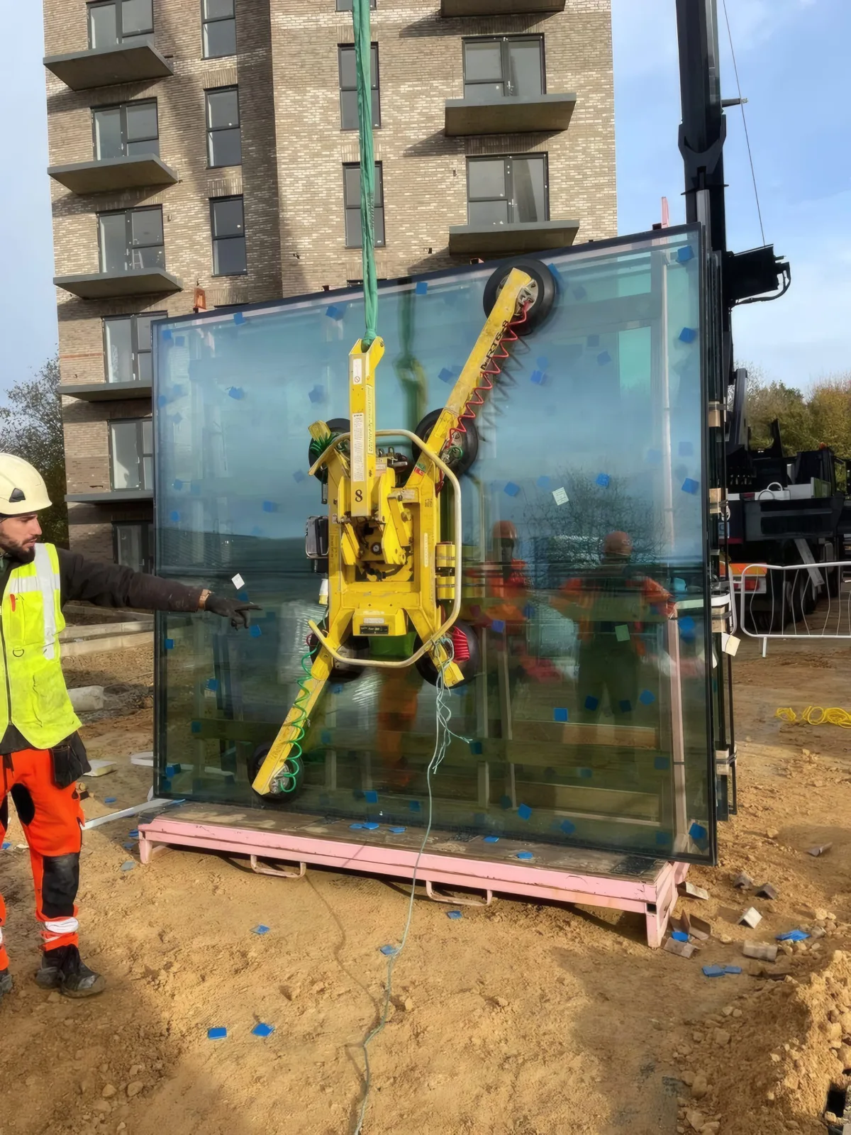 A glazing unit on its vacuum lifter, prepared at ground level ahead of lifting.
