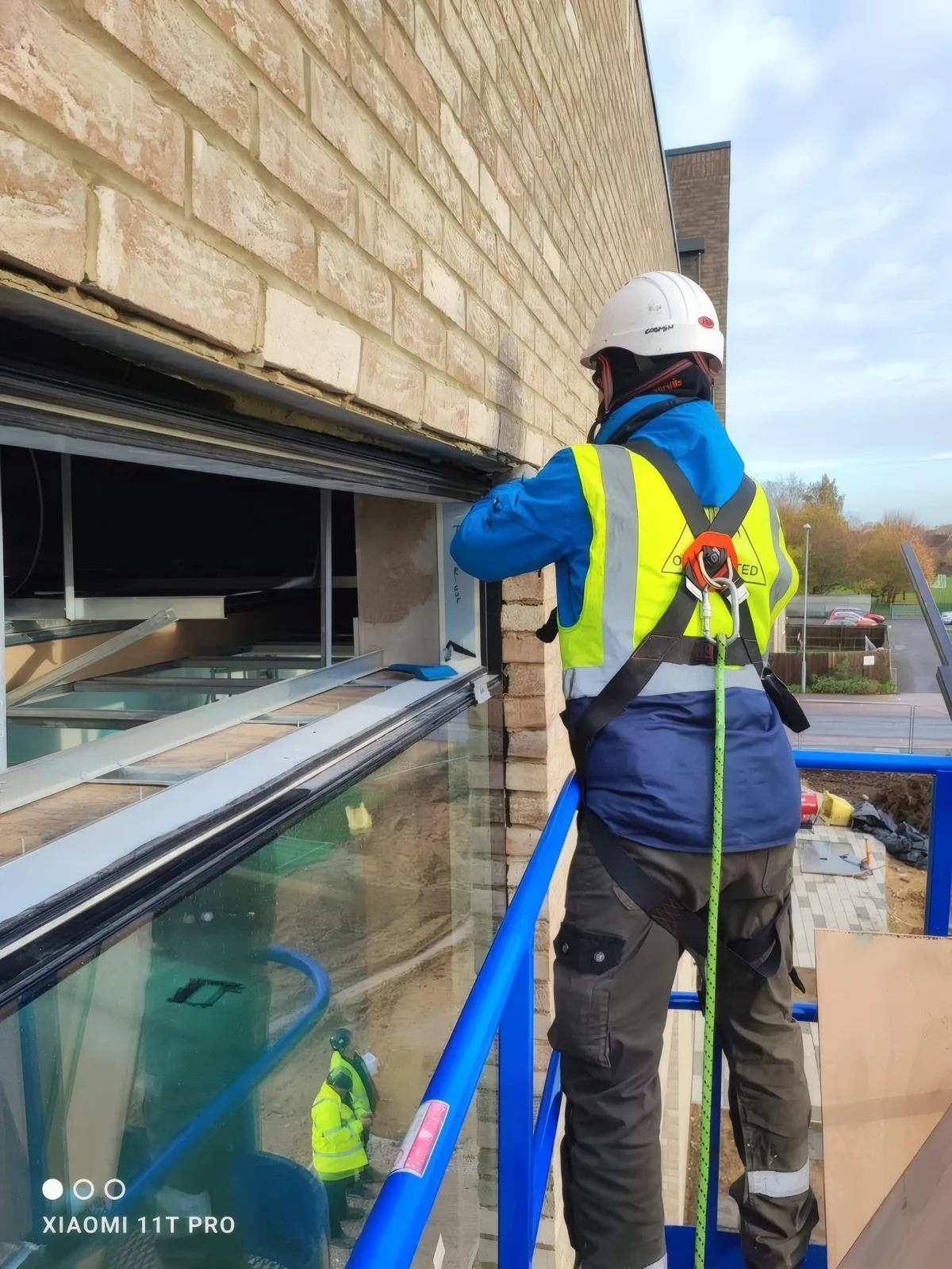 Sealing and finishing a glazing unit frame from the access platform.