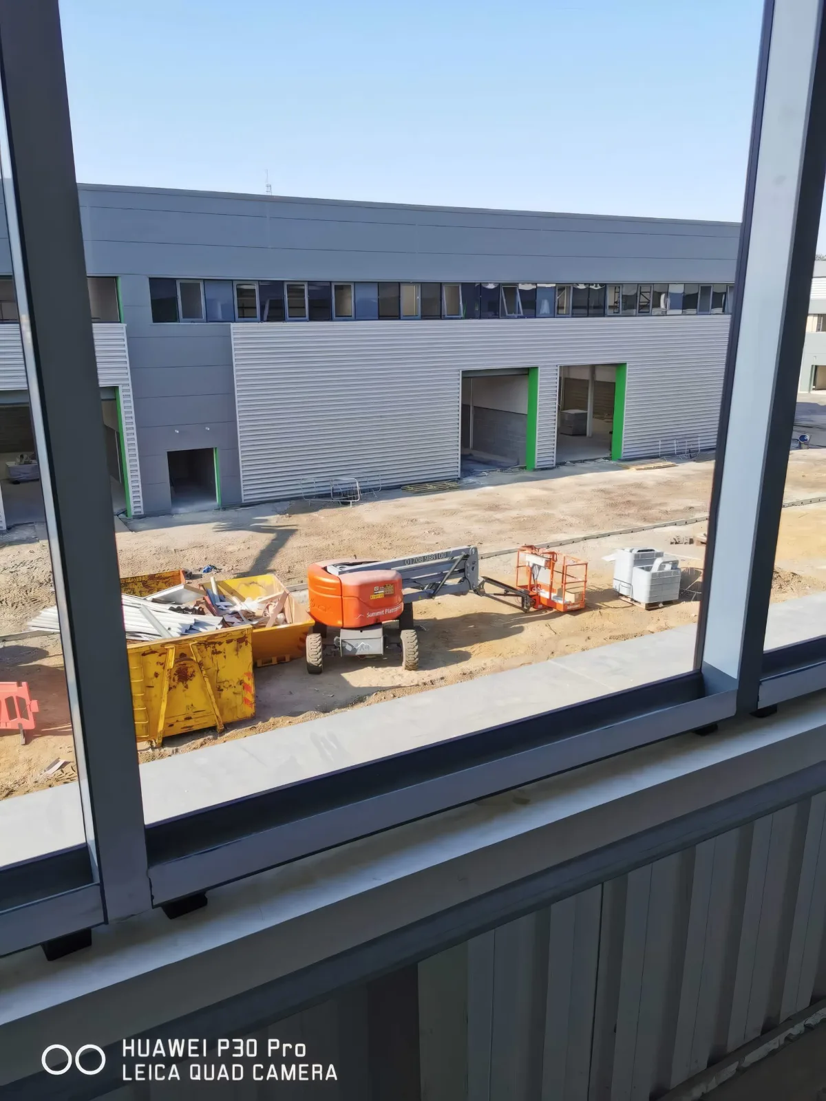 The yard seen through a newly fitted window frame, with access platforms below.