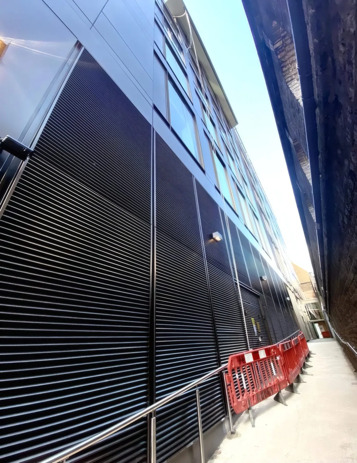 Aluminium louvre cladding installed to a service access area at ground level.