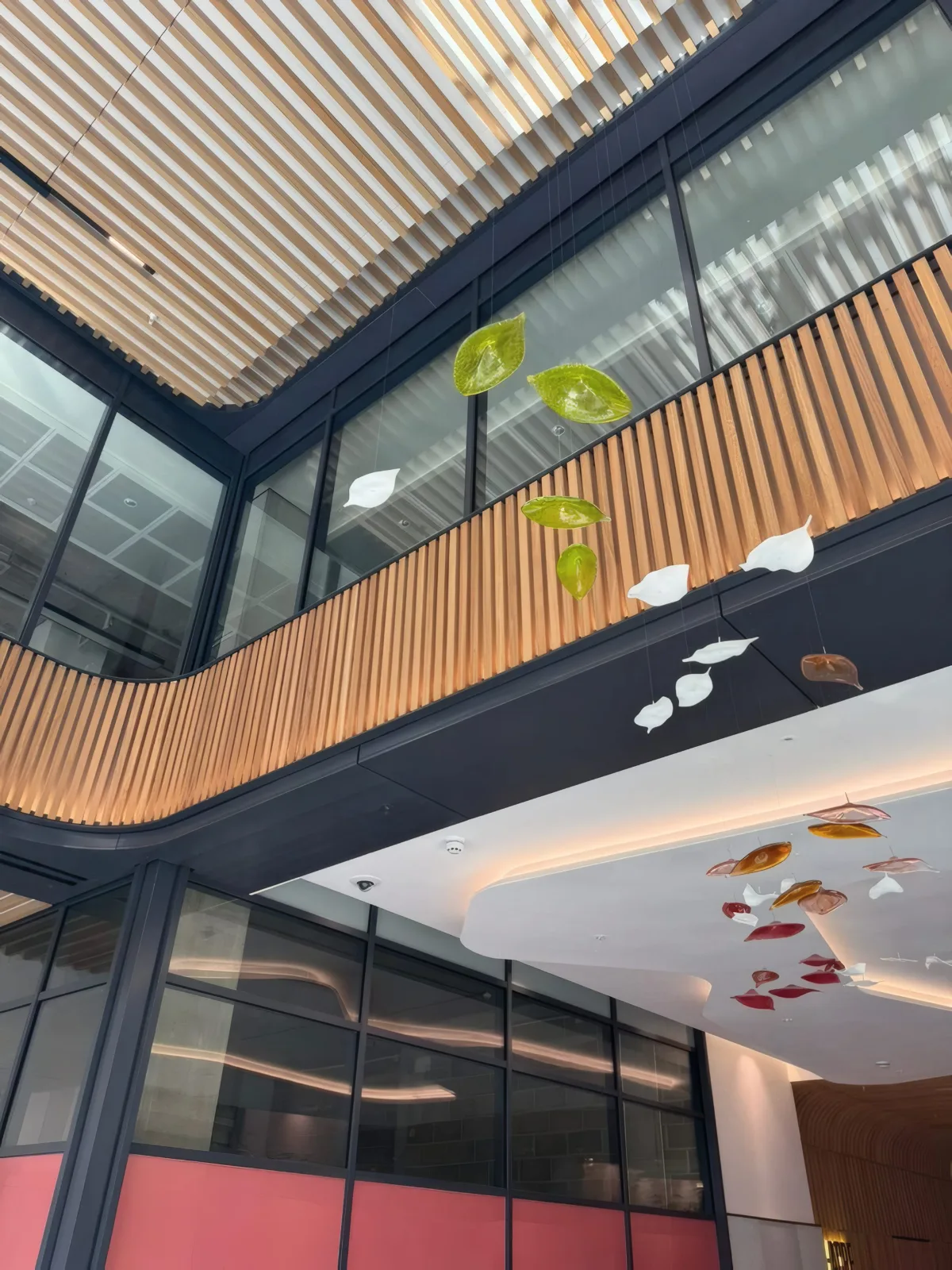 The multi-storey glazed atrium facade, viewed from the atrium floor.