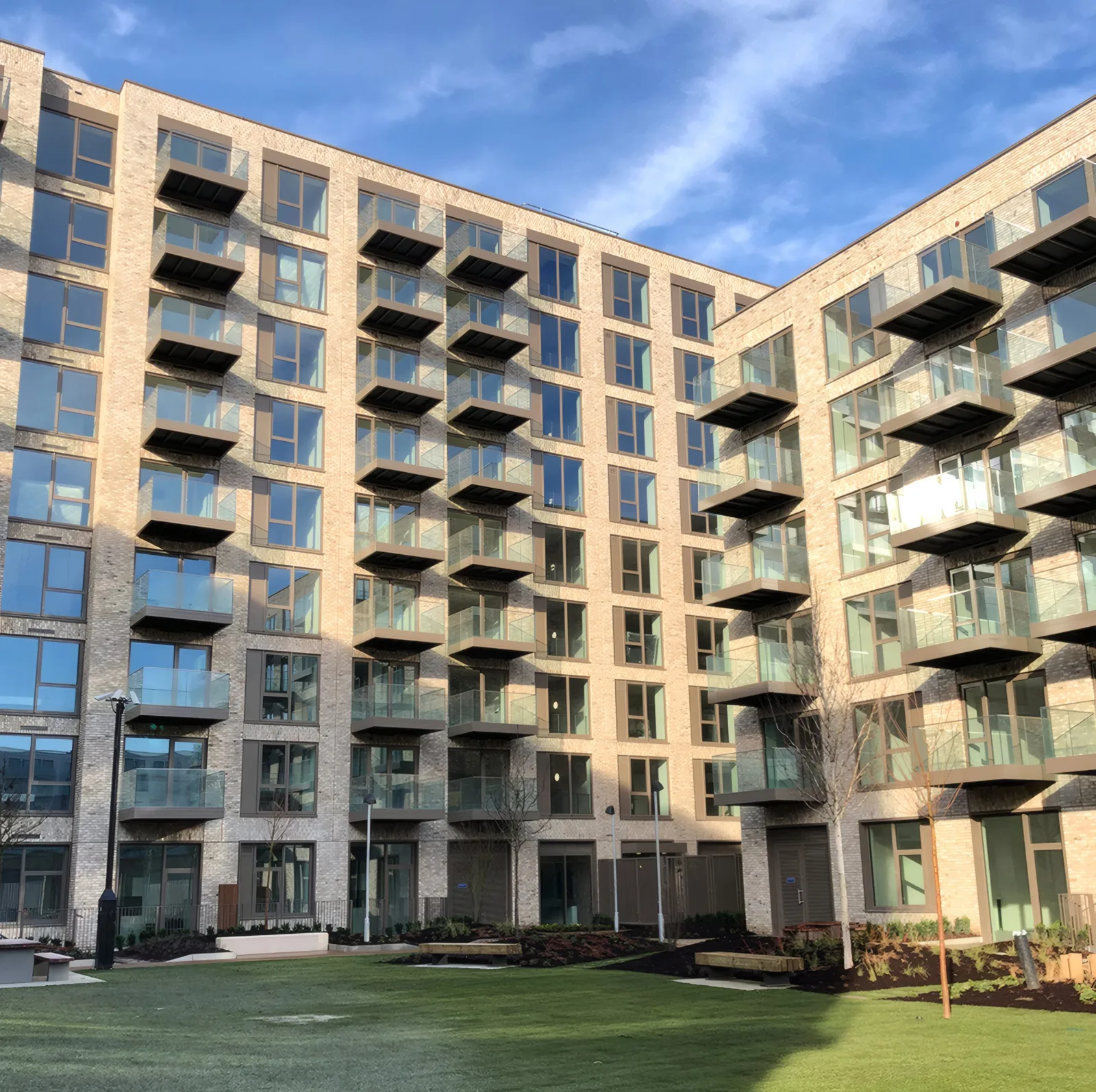 Apartment buildings with projecting balconies around a garden square.